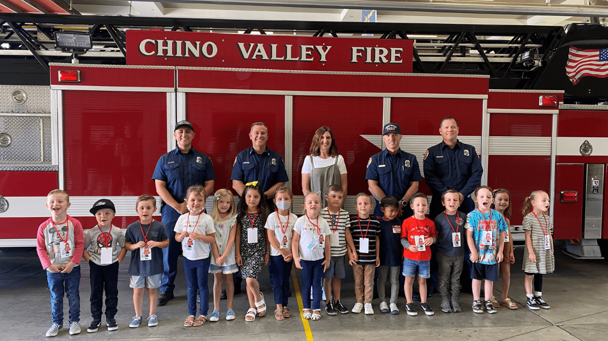 Chino Valley Firefighters posing with students at a Fire Station Tour